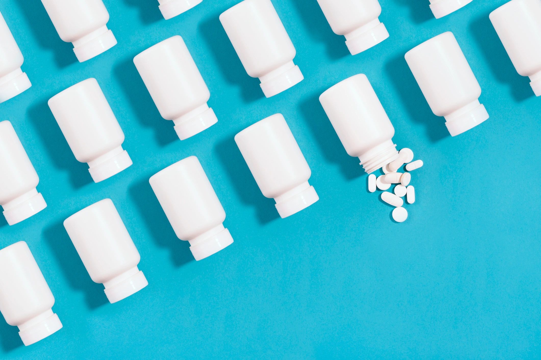 Supplement bottle and capsules on a blue background