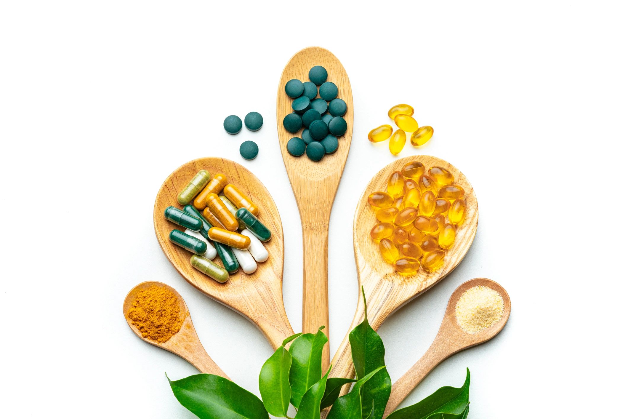 Longevity supplements and capsules on spoons