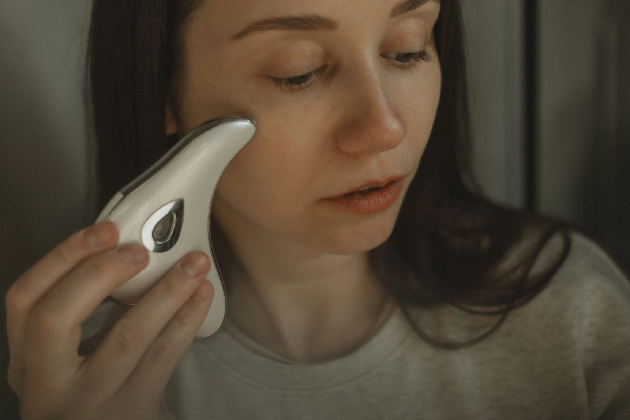 Woman using an at-home facial beauty device